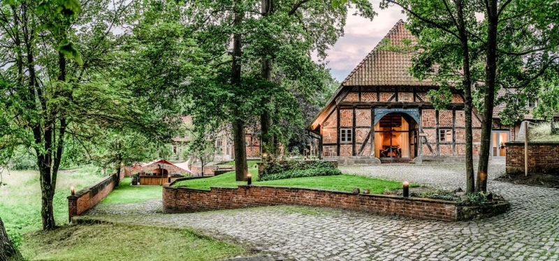 Hof mit Bäumen vor einem Fachwerkhaus