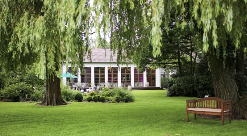 Haus unter Bäumen im Garten